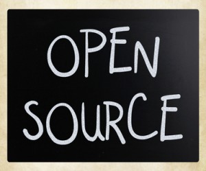"Open source" handwritten with white chalk on a blackboard